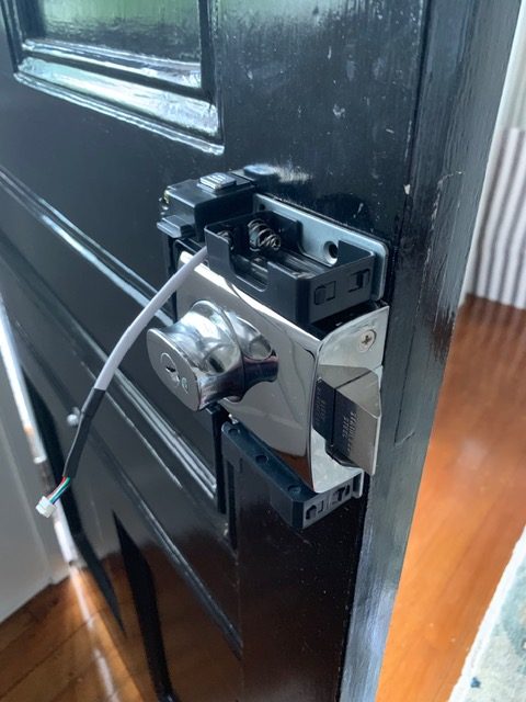 New chrome lockset installed on a gloss black front door
